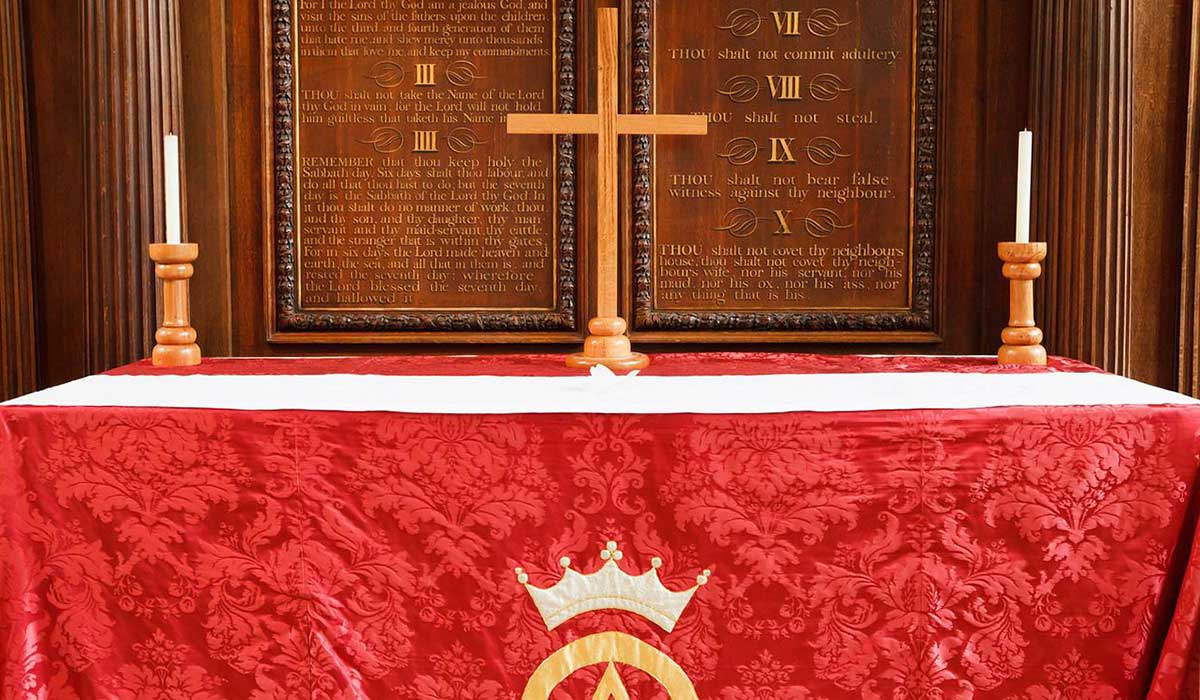 altar con cubierta roja y cruz en la iglesia.