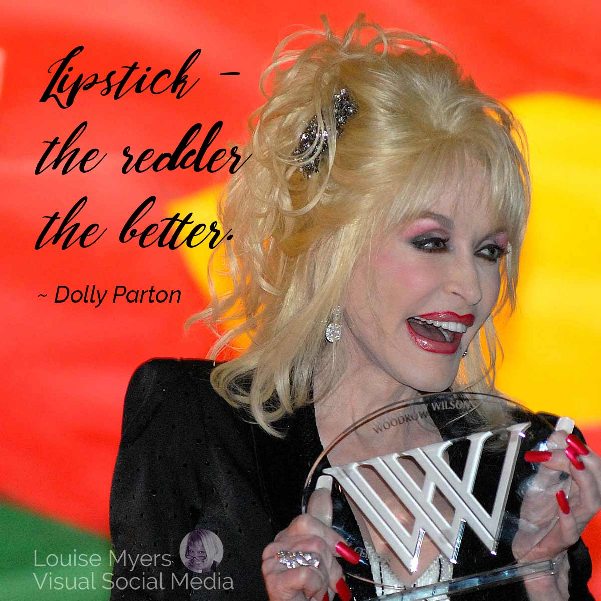 Dolly Parton acceptând premiul are rujul ei citat, cu cât mai roșu, cu atât mai bine.