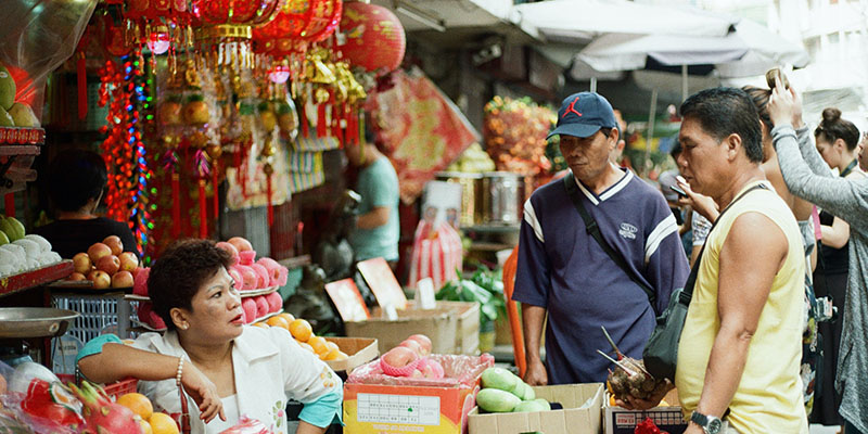 Un uomo che compra un frutto da un negozio cinese