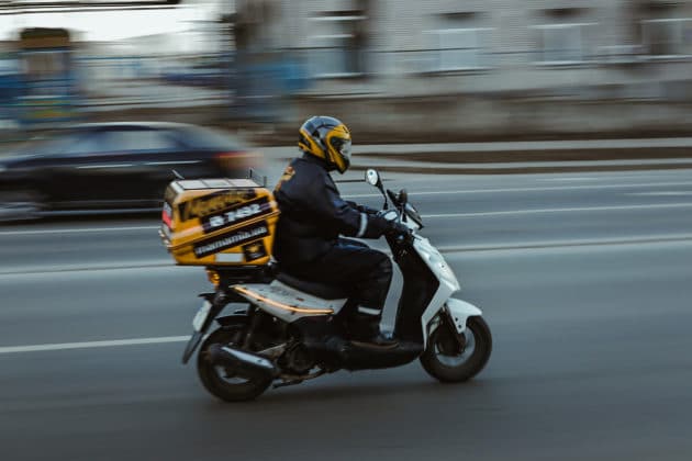 desenfoque de movimiento a tiempo-entrega-vehículo-transporte-motocicleta-scooter