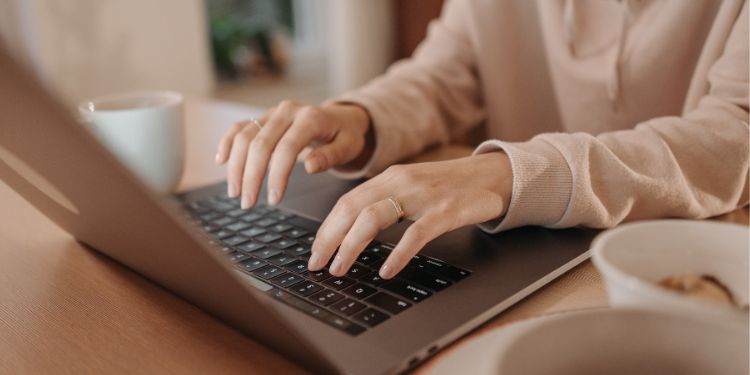 femme tapant sur un ordinateur à son bureau