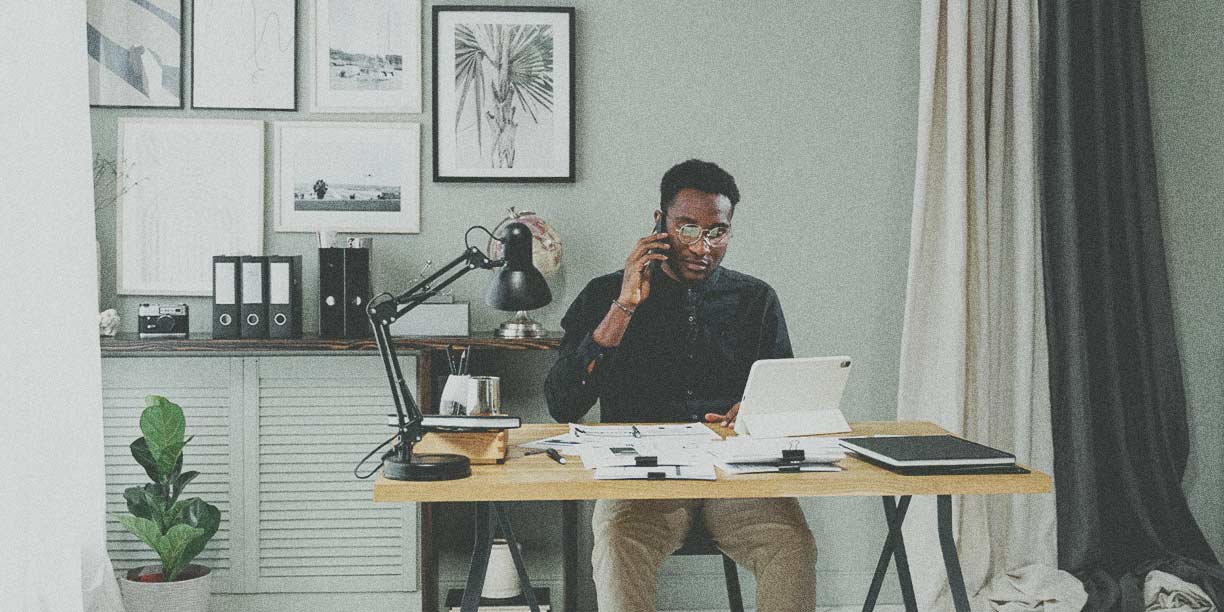 Homme en noir assis dans son bureau à domicile travaillant à un bureau