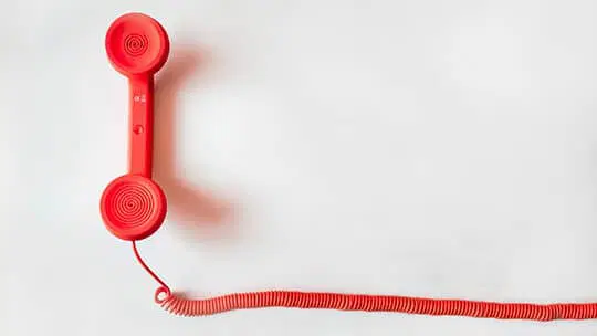 Un téléphone rouge sur fond blanc.