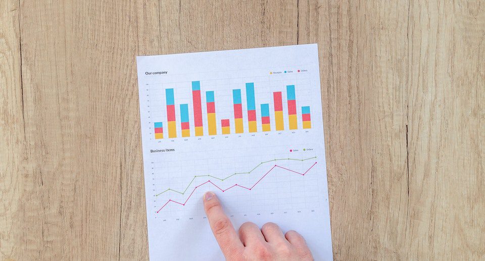 Una persona che legge i dati di un grafico sul tavolo